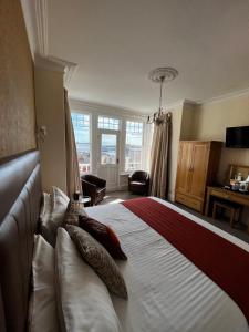 a bedroom with a large bed with pillows on it at Queenswood Hotel in Weston-super-Mare