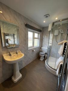 a bathroom with a sink and a shower and a toilet at Queenswood Hotel in Weston-super-Mare