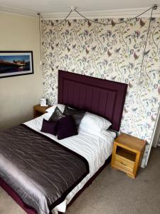 a bedroom with a large bed and a wall at Queenswood Hotel in Weston-super-Mare