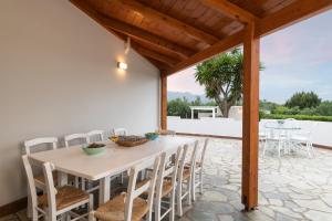 a dining room with a table and chairs on a patio at Villa Tranquilla in Kolymvari