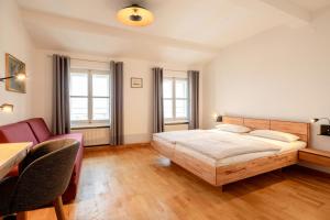 een slaapkamer met een bed en een tafel en stoelen bij Goldenes Schiff in Passau