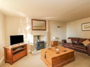 a living room with a couch and a television and a coffee table at Beautiful 3-Bed House in Longnor near Buxton in Longnor