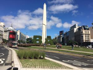 Una calle con un autobús pasando el monumento de Washington en Dumont Urban Studio en Buenos Aires