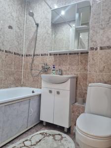 y baño con aseo, lavabo y ducha. en Посуточная квартира на Курмангазы c Wi-Fi en Uralsk