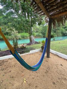 una hamaca colgada de una pérgola junto a un río en Rancho tres Marías, en Córdoba