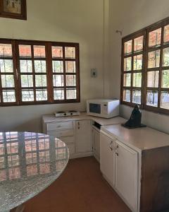 a kitchen with a table and a microwave at Rancho tres Marías in Córdoba