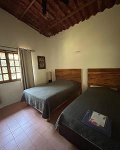 1 dormitorio con 2 camas y ventana en Rancho tres Marías, en Córdoba