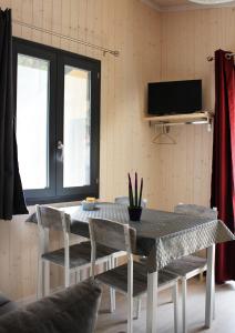 a dining room with a table and chairs and a tv at Camping la Pineta in Santa Maria Maggiore