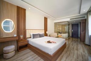 Un dormitorio con una gran cama blanca y un baño. en 7 Seven Sea Hotel, en Da Nang 62 fotos más