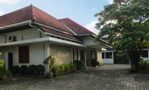 uma casa branca com um telhado vermelho em Hotel Graha Kinasih Kotabaru em Yogyakarta
