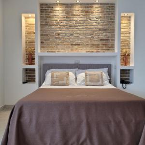 a bedroom with a large bed with a brick wall at Domus Romulea in Bisaccia