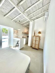 um quarto branco com uma cama e uma cozinha em Casa XS em Alvor