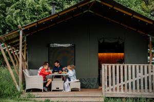 una familia sentada en una mesa en un cobertizo en Nature's Nest, en Hereford