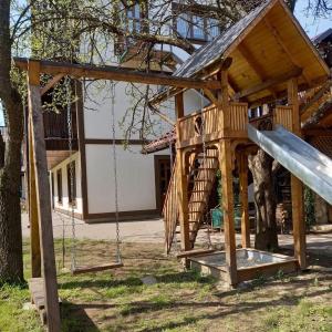 een houten speeltuin met een glijbaan in een tuin bij Voyage Tatariv in Tatariv