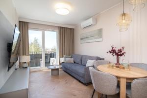 una sala de estar con un sofá y una mesa en Apartamenty Fale Morskie, en Jastrzębia Góra