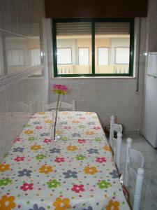 een tafel met een bloemstuk erop bij GP Guest House in Alvor