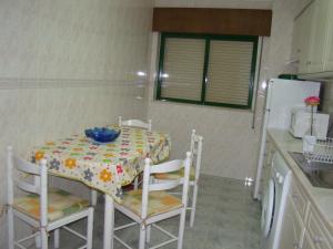 uma cozinha com uma mesa e cadeiras e um frigorífico em GP Guest House em Alvor