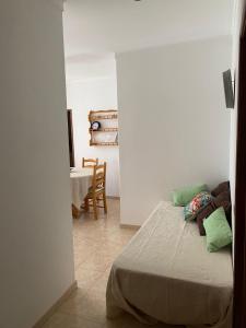 a bedroom with a bed and a dining room with a table at GP Guest House in Alvor