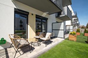 Un patio con sillas y una mesa en un balcón. en Apartamenty Fale Morskie, en Jastrzębia Góra