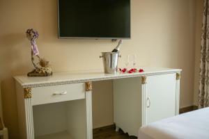 a white table with a television on top of it at Hotel Vila Mare in Durrës