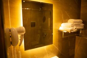uma casa de banho com um espelho, um telefone e toalhas em Hotel Vila Mare em Durrës