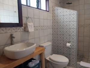 a white bathroom with a sink and a toilet at Curuba Lodge in El Copey