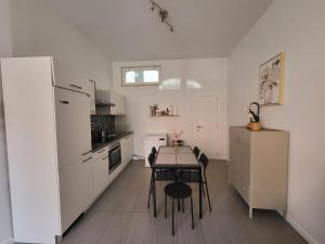 a kitchen with a table and a white refrigerator at House of Mima in Brussels