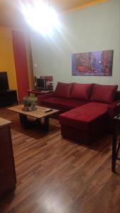 Sala de estar con sofá rojo y mesa de centro en Top Floor Apartment en Komotini