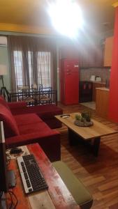 a living room with a red couch and a table at Top Floor Apartment in Komotini