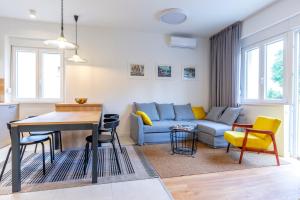 a living room with a blue couch and a table at Split Luxury Suite in Split