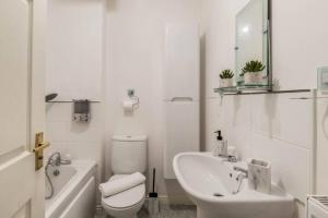 a white bathroom with a toilet and a sink at Lolite Homes - 4 Bed Perfect for NEC Genting Arena Resort World & Airport - Serviced Hawk Home in Birmingham