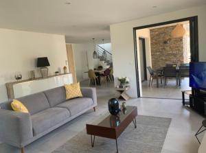 Una sala de estar con un sofá y un comedor. en Porto Vecchio Villa Bagatelle 8 personnes, en Porto Vecchio