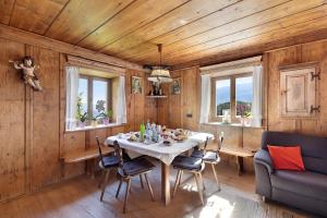 uma sala de jantar com mesa, cadeiras e janelas em Moar im Rumsein - Apt Saltenblick em Terlano