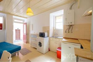 a kitchen with a washer and a washing machine at Casa do Castelo in Lisbon