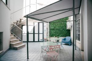 een patio met een tafel, stoelen en een trap bij Il Cortile by Vista Napoli in Napels