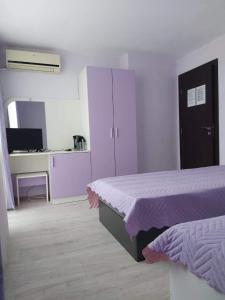 a bedroom with a bed and a desk with a computer at Guest House Perla in Obzor