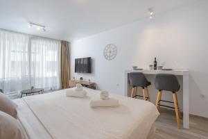 ドゥブロヴニクにあるLuni Apartment in Dubrovnik centerの白い部屋(ベッド1台、テーブル、椅子付)