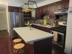 a kitchen with a counter and two stools in it at 4 Bedroom 3 bathroom 6 queen bed 5 full floor mattress with backyard Whole house for travel or vacation public and celebration group gatherings in Toronto