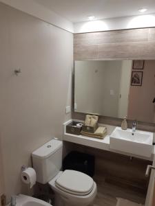 a bathroom with a toilet and a sink and a mirror at Godoy House in Buenos Aires