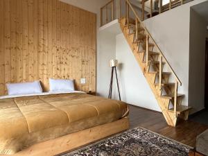 a bedroom with a bed with a wooden wall at The Bulevar - Whispering Willows in Sissu