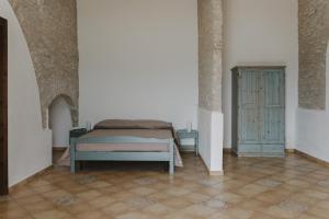 a bedroom with a bed and a cabinet at Masseria Baglio Perciata in Camporeale