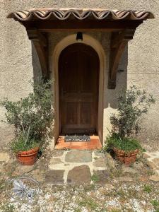 een toegang tot een gebouw met een houten deur bij Maison Amandre en Pleine Nature - Mas Lou Castanea in Collobrières