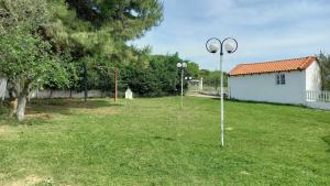 a yard with two street lights in the grass at Isidoros house in Néa Sílata