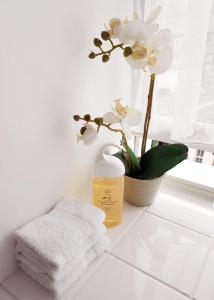 un bagno bianco con un asciugamano e fiori su un bancone di Dorchester House a Keswick