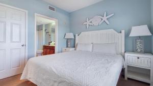a bedroom with a white bed and a blue wall at Laketown Wharf #1319 by Nautical Properties in Panama City Beach +59 photos
