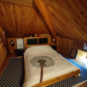 a bedroom with a bed with a tree on it at Gite de La Pierre Trouée in Châteauneuf-de-Randon