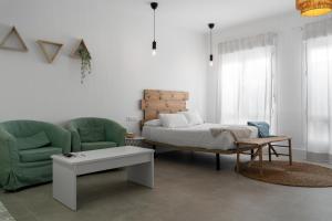 ein Schlafzimmer mit einem Bett, einem Stuhl und einem Tisch in der Unterkunft Apartamentos GAV in Ronda