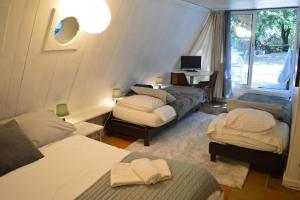 a room with three beds and a desk with a computer at Casa mARTa : Suites, terrasses et vue panoramique in Tournon-sur-Rhône