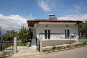 a white house with a fence in front of it at casa bianca in Nea Kallikrateia