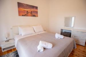 a bedroom with a large white bed with towels on it at casa bianca in Nea Kalikratia